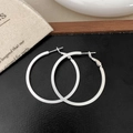 Macro view of silver matte oversized hoop earrings with sleek pin closure on black surface - Silver 2cm x 40mm