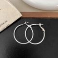 Dettaglio di orecchini a cerchio in argento su sfondo scuro con elementi decorativi - Argento 1.5cm x 30mm