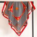 Red silk-feel square scarf with houndstooth pattern and retro tassel print hanging on a rack - Orange Border (FT246-2)