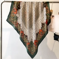 Detail of silk-like leopard print square scarf showing paisley borders and smooth texture - Green (FM181-1)