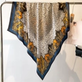 Detail showing elegant leopard and paisley print silk-like satin scarf on a silver rack - Blue (FM181-2)