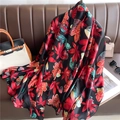 Detail of silk scarf with red and teal maple leaf patterns on a brown leather sofa - Red Black Teal Maple Leaf (XL132-2)