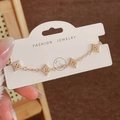 Dettaglio del bracciale dorato con stelle in zirconi su scheda di presentazione - Bracciale In Zirconia Bianca Oro