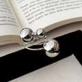 Macro d'une bague spirale argentée avec trois sphères en métal poli au design minimaliste - Bague Grande Sphère Argentée