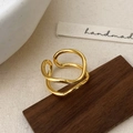 Macro view of a gold irregular wave ring with high-polish finish and adjustable open design - Gold
