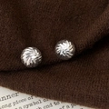 Macro shot of silver circular stud earrings with radiant faceted texture on knit fabric - Round Radial Style / Silver