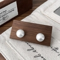 Dettaglio di orecchini a sfera in argento spazzolato opaco su un display in legno di noce - Orecchini a bottone spazzolati argento 12mm