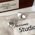 Makroaufnahme minimalistischer silberner Ohrstecker mit dunkelgrauer Perle auf Leinwand - Silber mit grauer Muschelperle