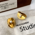Detailansicht goldener Bogenohrringe mit weißer Perle auf einer Samtbox - Gold mit weißer Muschelperle