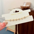 Primer plano de pulsera ajustable de estrellas doradas con circonitas y tarjeta de moda - Dorado