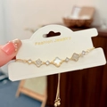 Detail of clover bracelet with white shell inlays and crystals on a display card - Four Leaf Flower (Gold) / Gold
