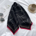 Dettaglio di sciarpa in raso con linee bianche e bordo rosso su sfondo di tessuto - Nero Rosso