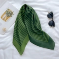 Detail shot of green striped silk square scarf with sunglasses and golden brooch - Green