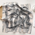 Détail d'un foulard en soie léger aux motifs géométriques noir et blanc sur plateau bois - Style de Feuille Noir et Blanc (FR14-1)