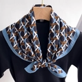 Detail of blue and brown geometric woven silk scarf styled on a sweater with hanger - Blue Brown Geometric (FR26-2) / 68x68cm