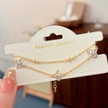 Detail van gouden dubbellaagse klaverarmband met fonkelende ingelegde zirkoniasteen - Goud