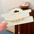 Detail of adjustable gold butterfly bracelet with shimmering cat eye stone and zircons - Gold