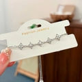 Dettaglio di un bracciale regolabile con stelle d'argento e zirconi su supporto - Stile Stella Cava / Argento
