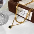Detail of double-layered gold necklace with flat snake chain and emerald green pendant - Green Zircon Pendant