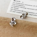 Nahaufnahme silberner gefalteter Cremer-Blumen-Ohrstecker mit abstraktem Falten-Design - Silber