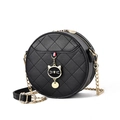 Chic black round quilted crossbody bag featuring a golden cat charm and chain strap - Black