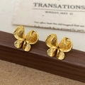 Detalle de pendientes de mariposa con acabado texturizado de latón bañado en oro - Pendientes de Mariposa Dorados