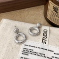 Orecchini geometrici in argento con trama martellata presentati su uno sfondo vintage - Stile Tondo Martellato Argento (A-1182)