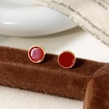 Detail of round red enamel stud earrings with gold trim on a vintage display stand - Large / Ancorra Red