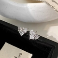 Vista macro dettagliata di orecchini a cuore in argento con fiocco e zirconi cubici - Orecchini a Bottone con Fiocco a Cuore in Zircone Bianco Argentato (A-1862)
