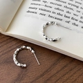 Orecchini a C in argento minimalisti con superficie sfaccettata su sfondo di libro - Orecchini a Bottone Geometrici Sfaccettati (A-1827)