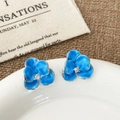 Macro detail of blue floral enamel earrings with central zircon on white porcelain - Blue Flower (A-1644)