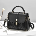 Bolso de mano negro clásico con textura a rayas y cierre dorado en soporte blanco - Negro