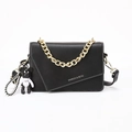 Black leather crossbody bag with gold chain strap and black bear charm accessory - Black