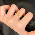 Elegant gold croissant ring with beaded design worn on hand against a black leather background - Beaded Oval Style (C-196)