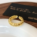 Macro detail of gold adjustable open ring with ribbed vertical texture on a ceramic plate - Gold Pointed Tail Open Ring