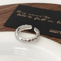 Macro view of silver croissant ring with vertical ridges on white ceramic tray - Silver Pointed Tail Open Ring
