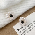 Detail of flower-shaped pearl earrings with black center on white knit fabric - A-1109-Black Center Studs
