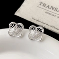 Primer plano de pendientes de flores plateadas con piedras de circón en una bandeja - Pendientes de Botón de Trébol de Cuatro Hojas de Circonita Hueca Plateada (A-1602)