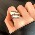 Dettaglio di un anello asimmetrico color argento con finitura a specchio lucida sulla mano - Stile Geometrico Liquido (C-186) / Argento
