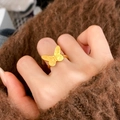 Detailed close-up of a golden butterfly ring with matte textured wings on a model's hand - C-383 Gold Butterfly Ring