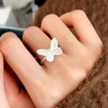 Detail of a matte silver butterfly ring with frosted texture worn on a finger - C-383 Silver Butterfly Ring
