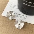Nahaufnahme silberner, quadratischer Ohrstecker mit Struktur auf Papier- und Kerzenhintergrund - Abgerundetes Quadrat Wellenstruktur Silber (A-1424)