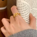 Minimalist golden wavy ring for women worn on index finger in a lifestyle setting - Irregular Wave Style (C-194) / Gold