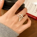 Detail of silver double bow open ring on finger in a cozy cafe lifestyle scene - Double Bow Knot Style (C-420) / Silver