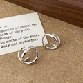 Close-up of minimalist silver intertwined double hoop earrings on a kraft paper background - Irregular Double Ring Intertwined Earrings (A-1642) / Silver