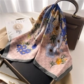Sciarpa di seta floreale rosa e grigia con trama satinata drappeggiata su una borsa - Grigio rosato