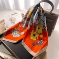 Foulard quadrato di seta floreale arancione appeso al manico di una borsa di pelle - Rosso Arancio