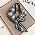 Detail of black and white houndstooth skinny scarf neatly folded on a suede tray - Black White Classic Houndstooth (CK21-1)