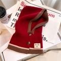 Close-up of a red knitted balaclava hood with brown trim and vintage buttons - Red and Coffee