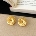 Détail des boucles d'oreilles torsadées dorées avec texture radiale sur papier - Boucles d'Oreilles Clous Spirales Multicouches Dorées (A-1659)